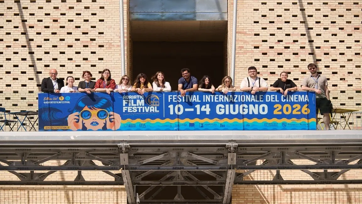 Il team dell'Adriatic Film Festival sul balcone con lo striscione dell'edizione 10—14 giugno 2026